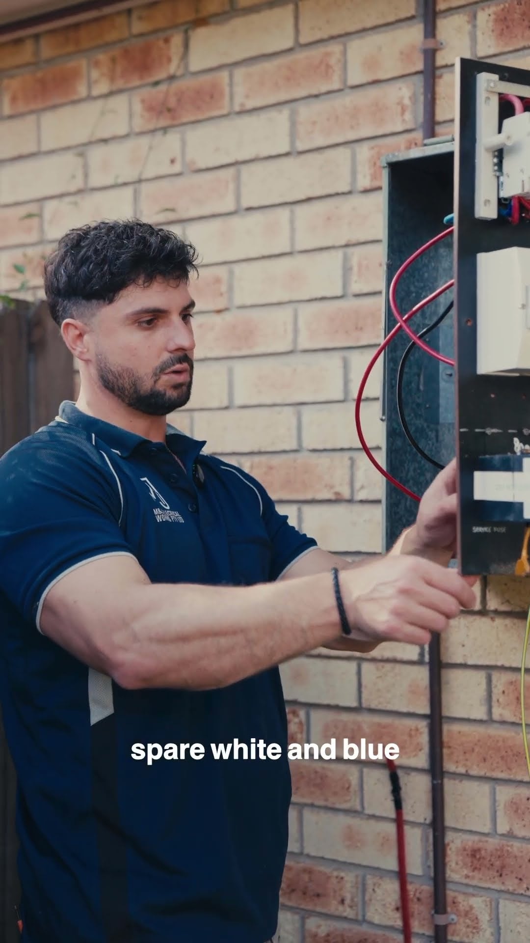 Electrician checking a switchboard while explaining a three-phase power upgrade