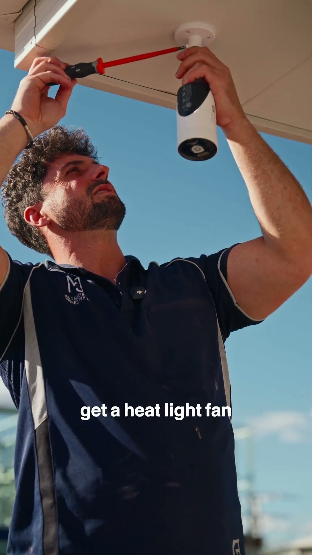 Electrician installing light fittings and CCTV at a new Oran Park home