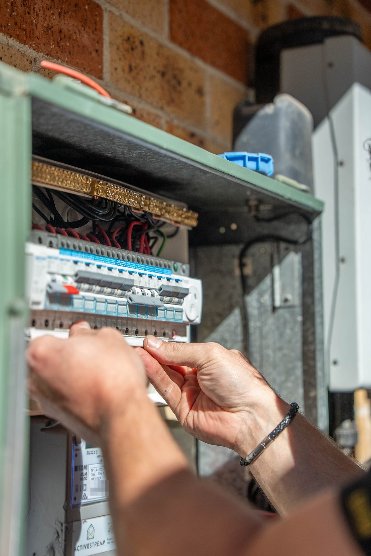 Close-up of an electrician fitting the new row of individual safety switches in a Cecil Hills switchboard