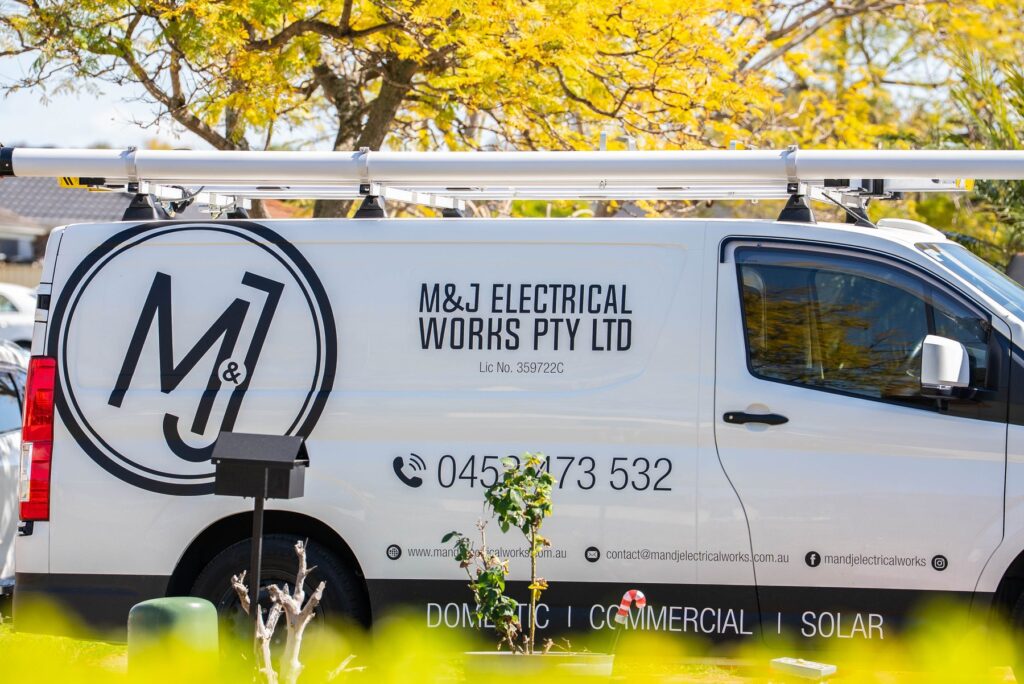 M&J Electrical Works van parked in a Hoxton Park street during an EV charger installation